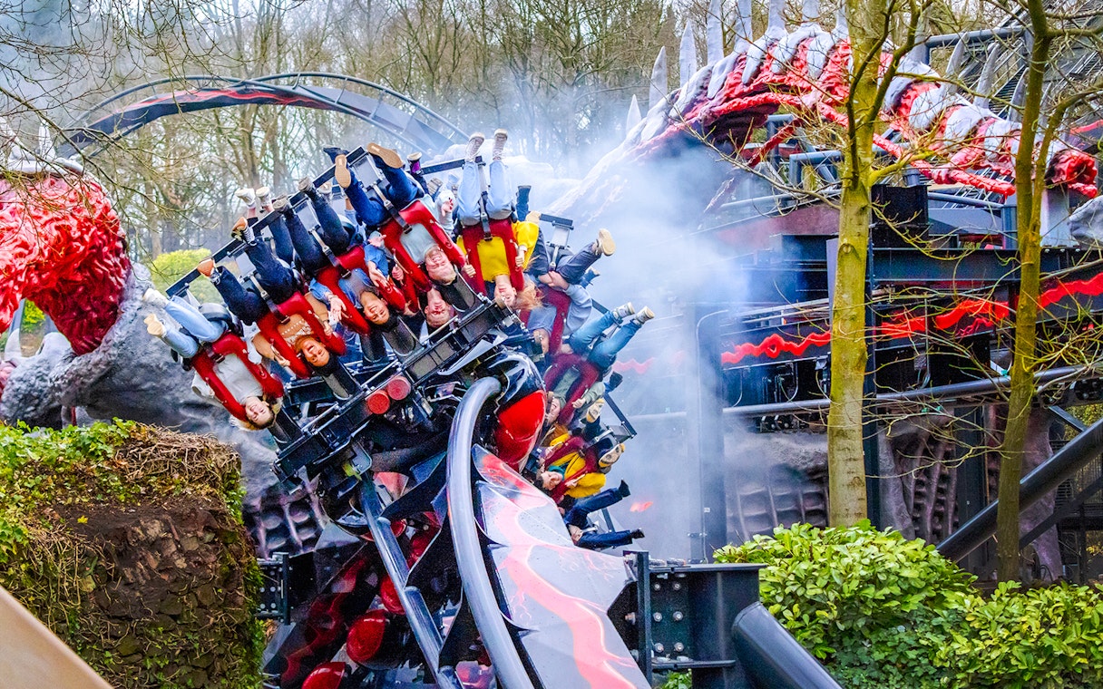 Riders on Nemesis Reborn roller coaster at Alton Towers, upside down on a loop.