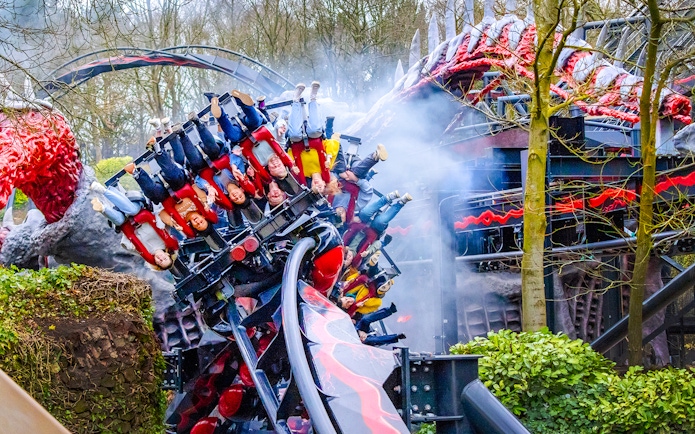 Riders on Nemesis Reborn roller coaster at Alton Towers, upside down on a loop.