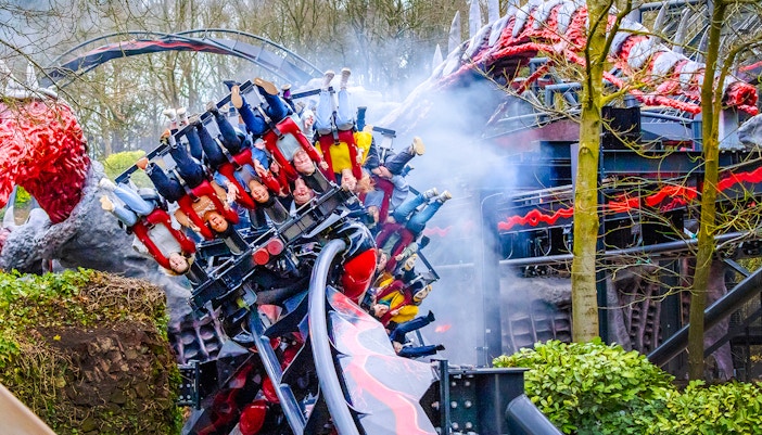 Riders on Nemesis Reborn roller coaster at Alton Towers, upside down on a loop.