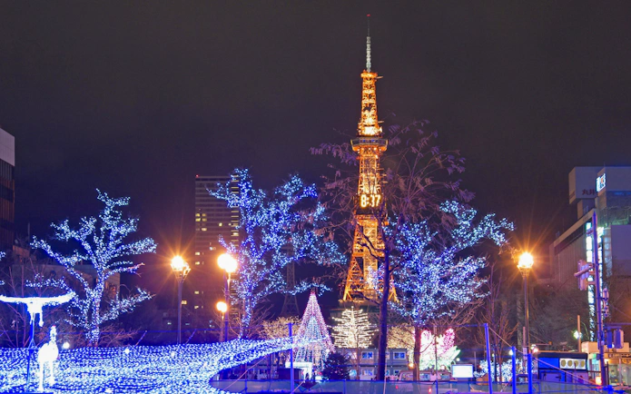 Sapporo TV Tower illuminated with winter holiday lights at night.