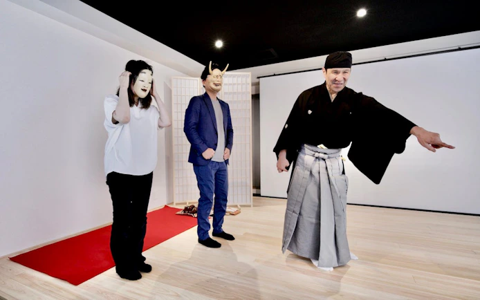 Noh theater workshop in Kyoto with participants wearing traditional masks and guided by a master performer.