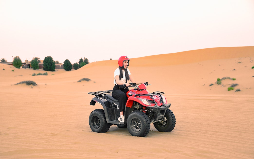 Person riding a quad bike in the Abu Dhabi desert.