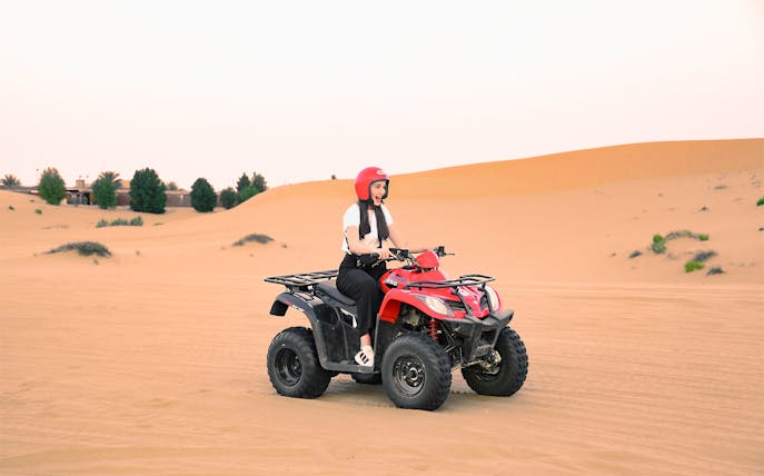 Person riding a quad bike in the Abu Dhabi desert.