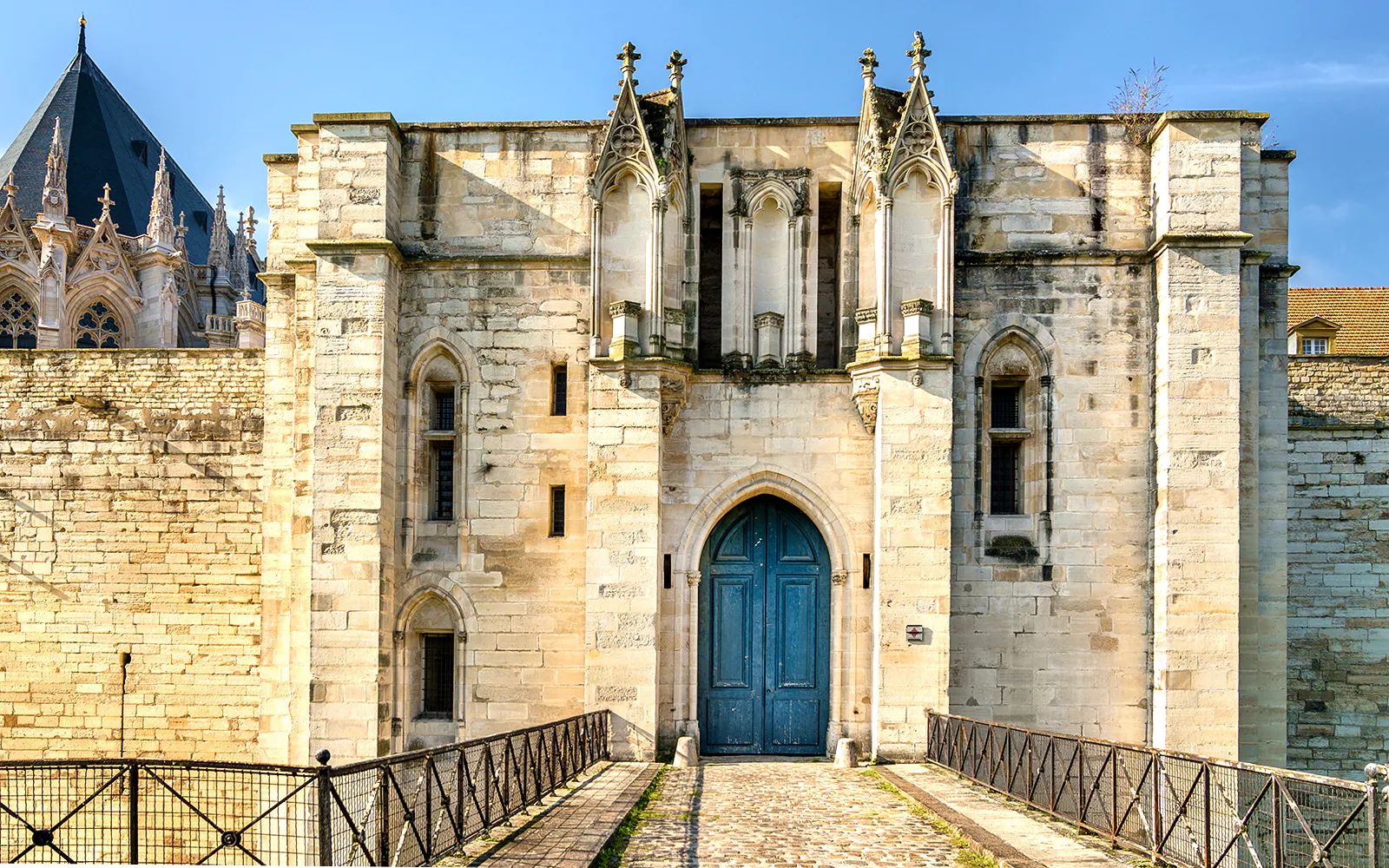 Château de Vincennes entrance with stone walls and blue door, Paris, France.