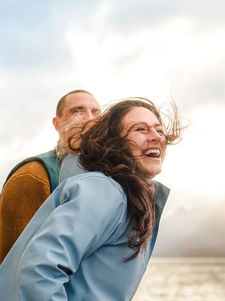 Woman laughing on boat deck during Doubtful Sound Wilderness Cruise, New Zealand.
