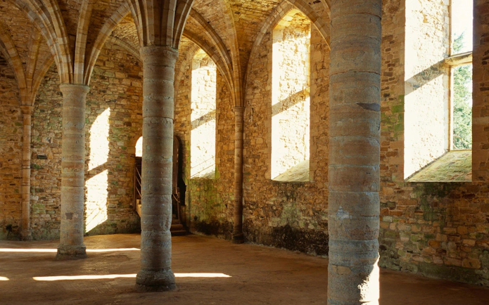 Interior of Battle Abbey with stone columns and arched ceilings.