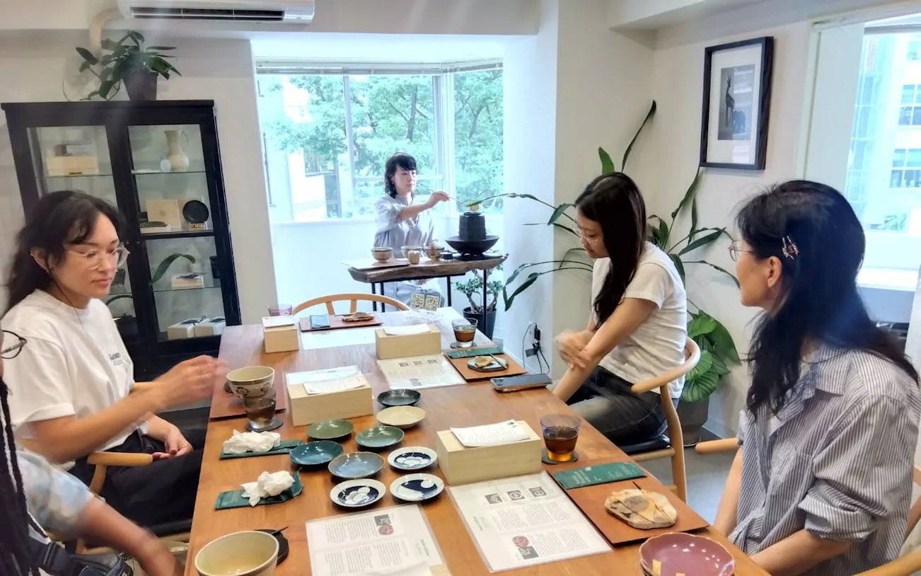 Small group at Kintsugi workshop in Shibuya, learning pottery repair with matcha and sweets.