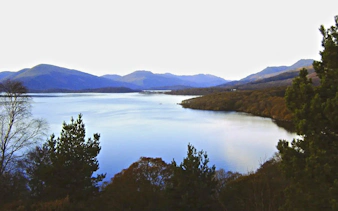 Loch Lomond view with surrounding hills and trees in Scotland.