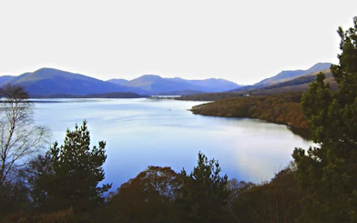 Loch Lomond view with surrounding hills and trees in Scotland.