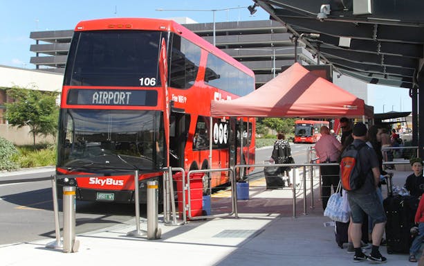 SkyBus Peninsula Express at Melbourne airport terminal with passengers boarding.