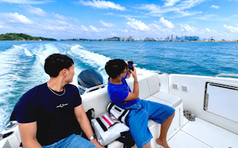 Two people relaxing on a speedboat in Sentosa, Singapore with a view of the tropical sea.