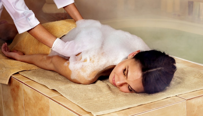 Woman receiving traditional foam massage at Turkish bathhouse in Istanbul