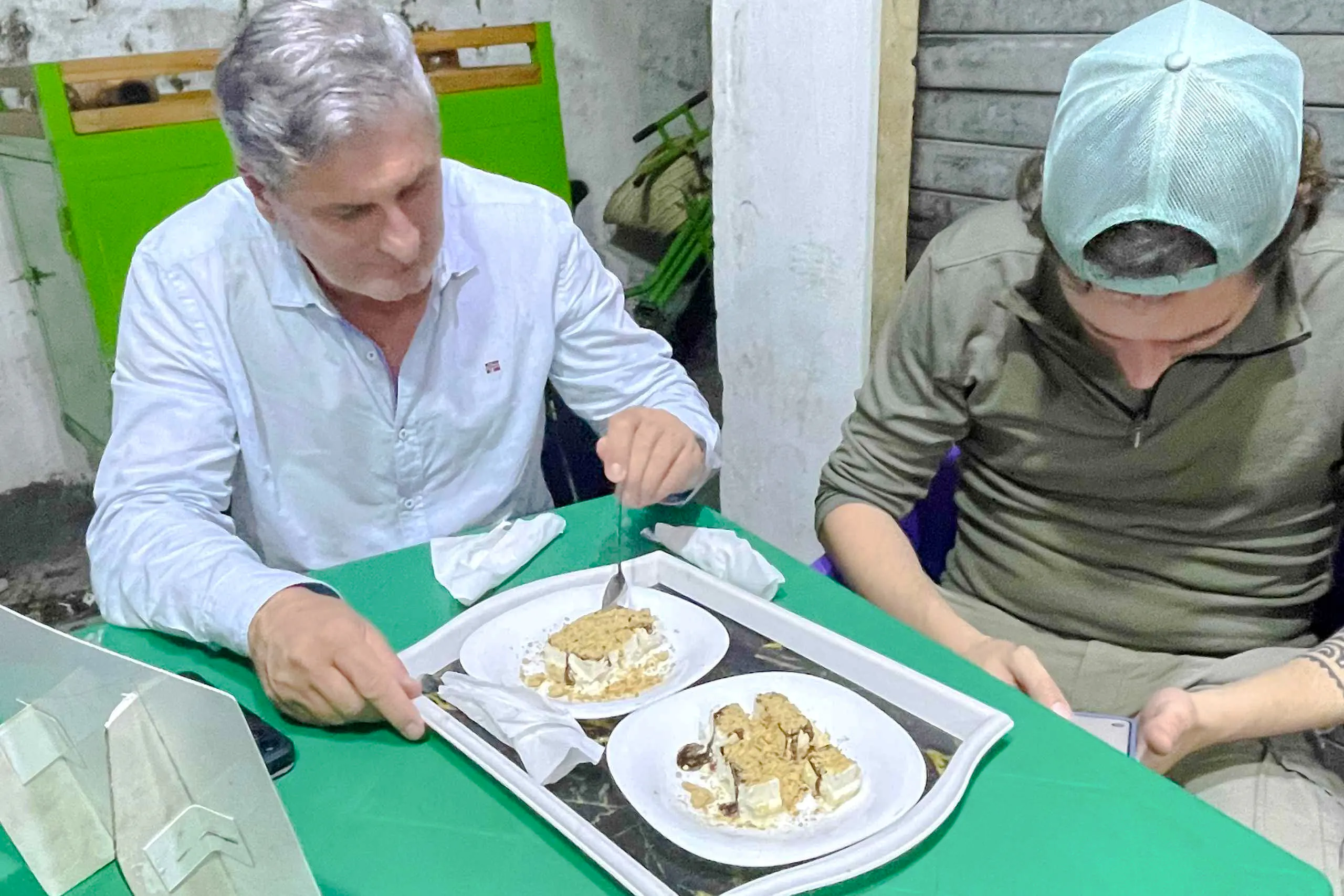 Two people enjoying local dessert on a food tour in Dar es Salaam, Tanzania.