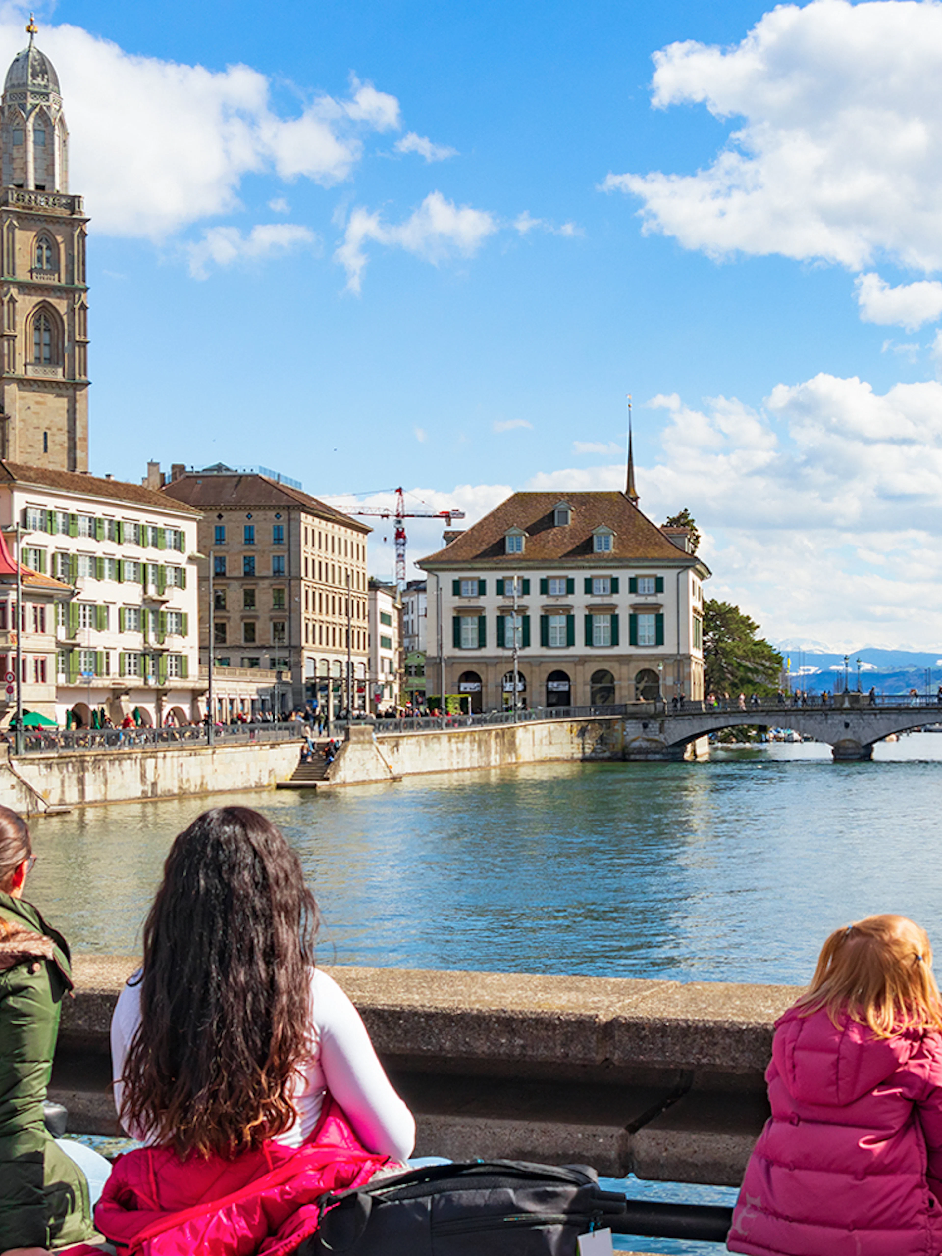 People enjoying the view of Grossmünster and Limmat River on Zürich city tour.