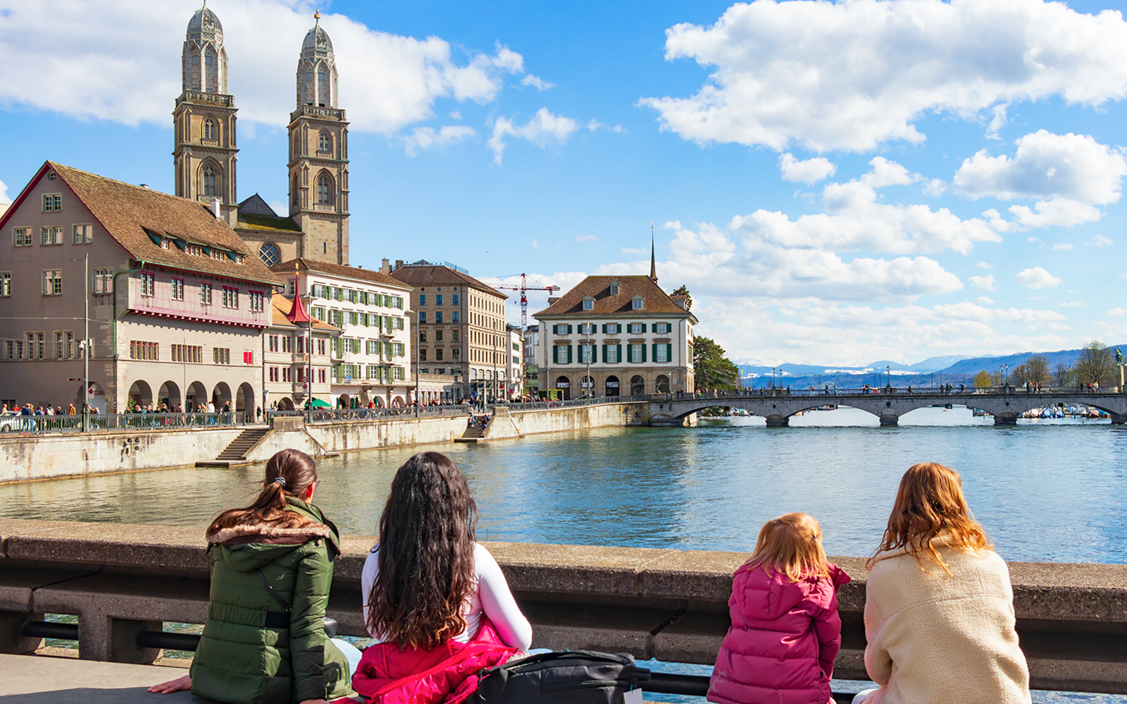 People enjoying the view of Grossmünster and Limmat River on Zürich city tour.