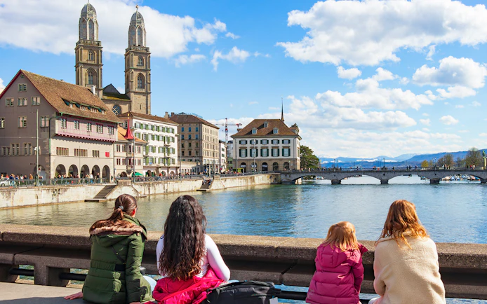 People enjoying the view of Grossmünster and Limmat River on Zürich city tour.