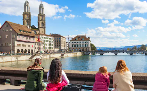 People enjoying the view of Grossmünster and Limmat River on Zürich city tour.