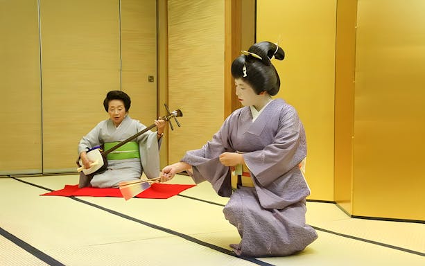 Geisha performing traditional dance with musician playing shamisen in Japan.