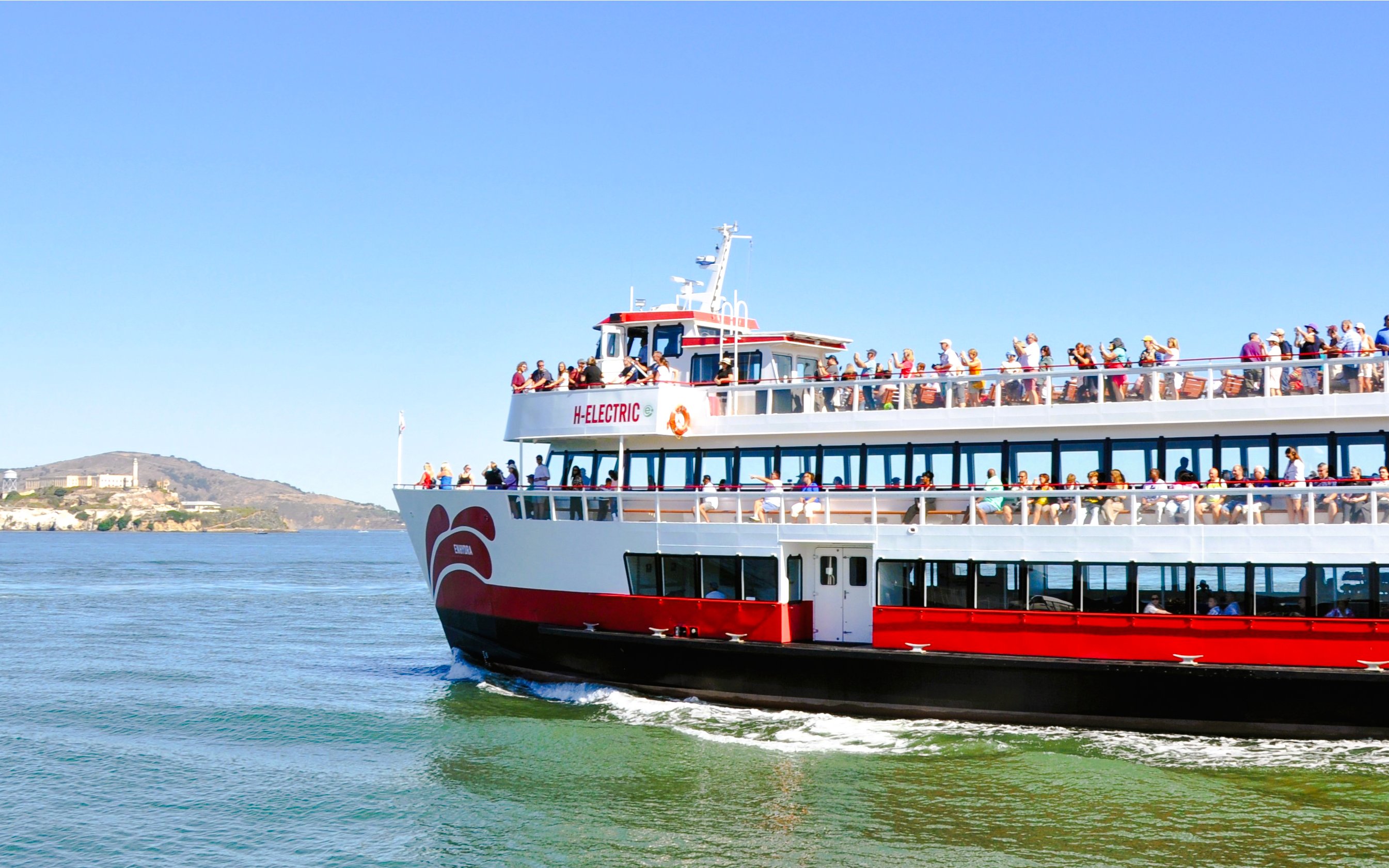Cruise ship with passengers near Alcatraz Island on Golden Gate Bridge tour.