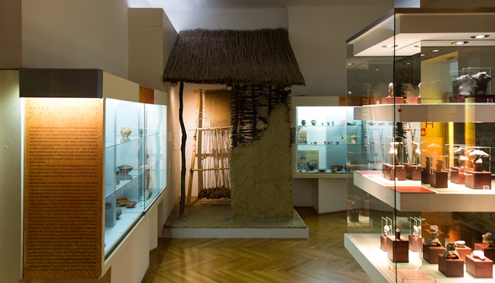 Exhibit of ancient pottery and tools in an Archaeological Museum display room.