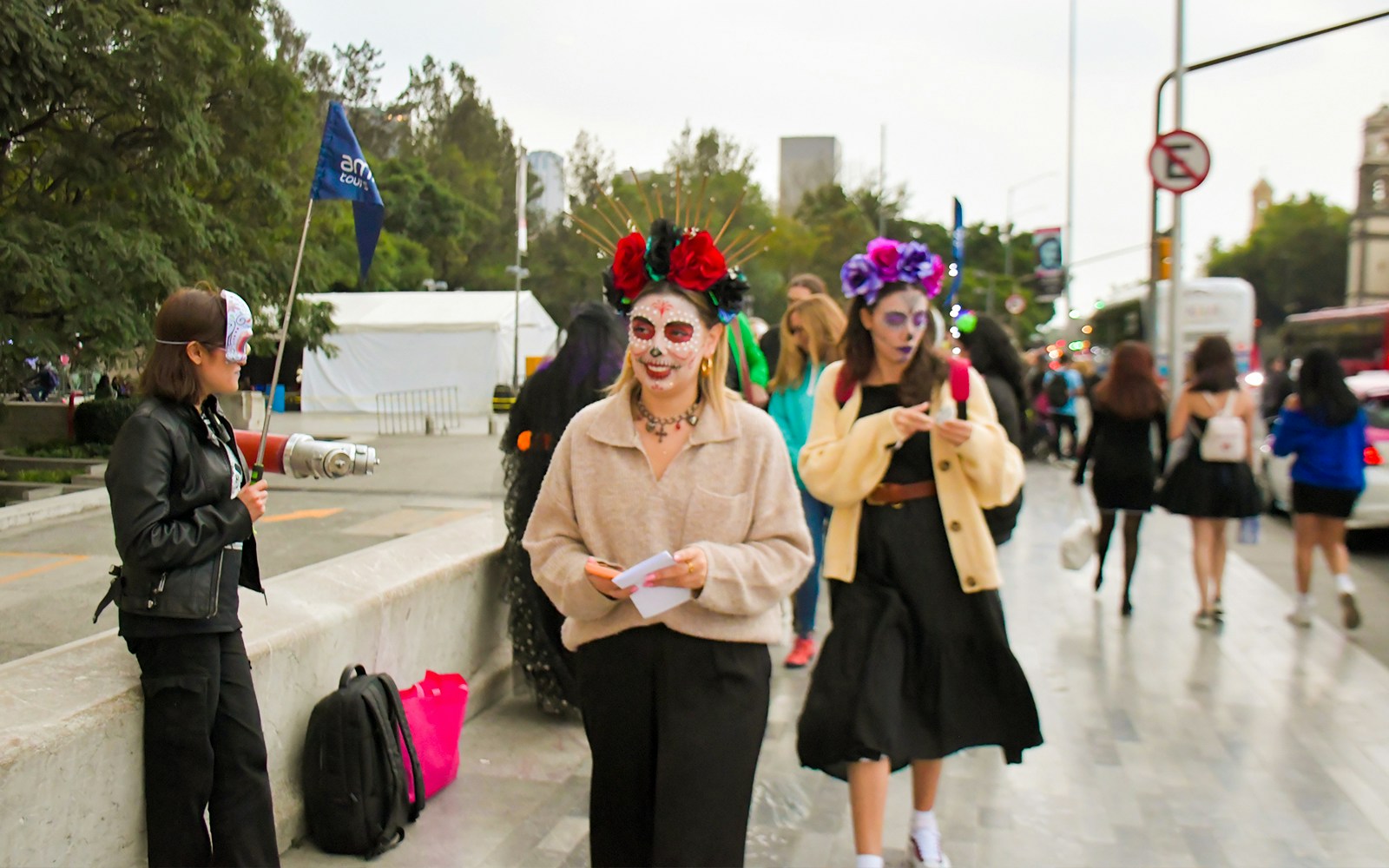 Tourists in face paint and costumes at Day of the Dead parade, Mexico City.