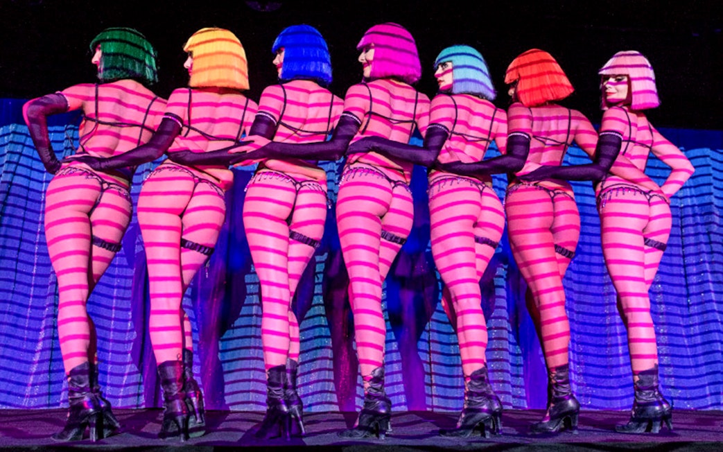 Dancers in colorful wigs performing at Crazy Horse show in Paris.