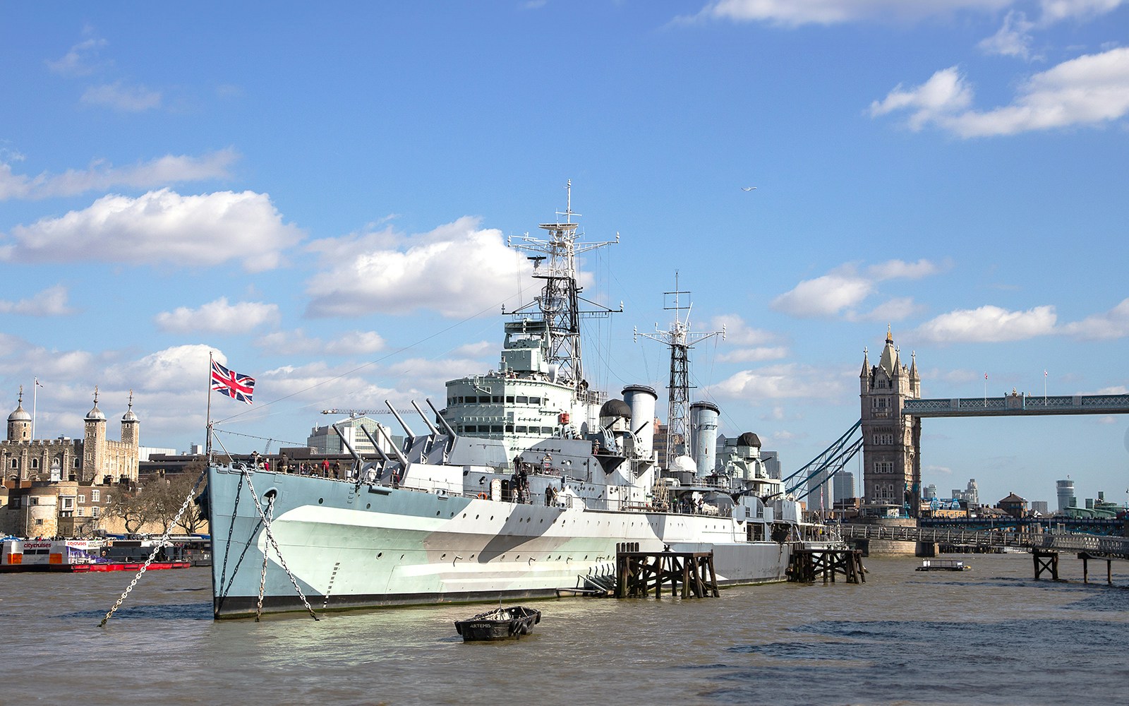 HMS Belfast moored on the River Thames with Tower Bridge in the background, London.