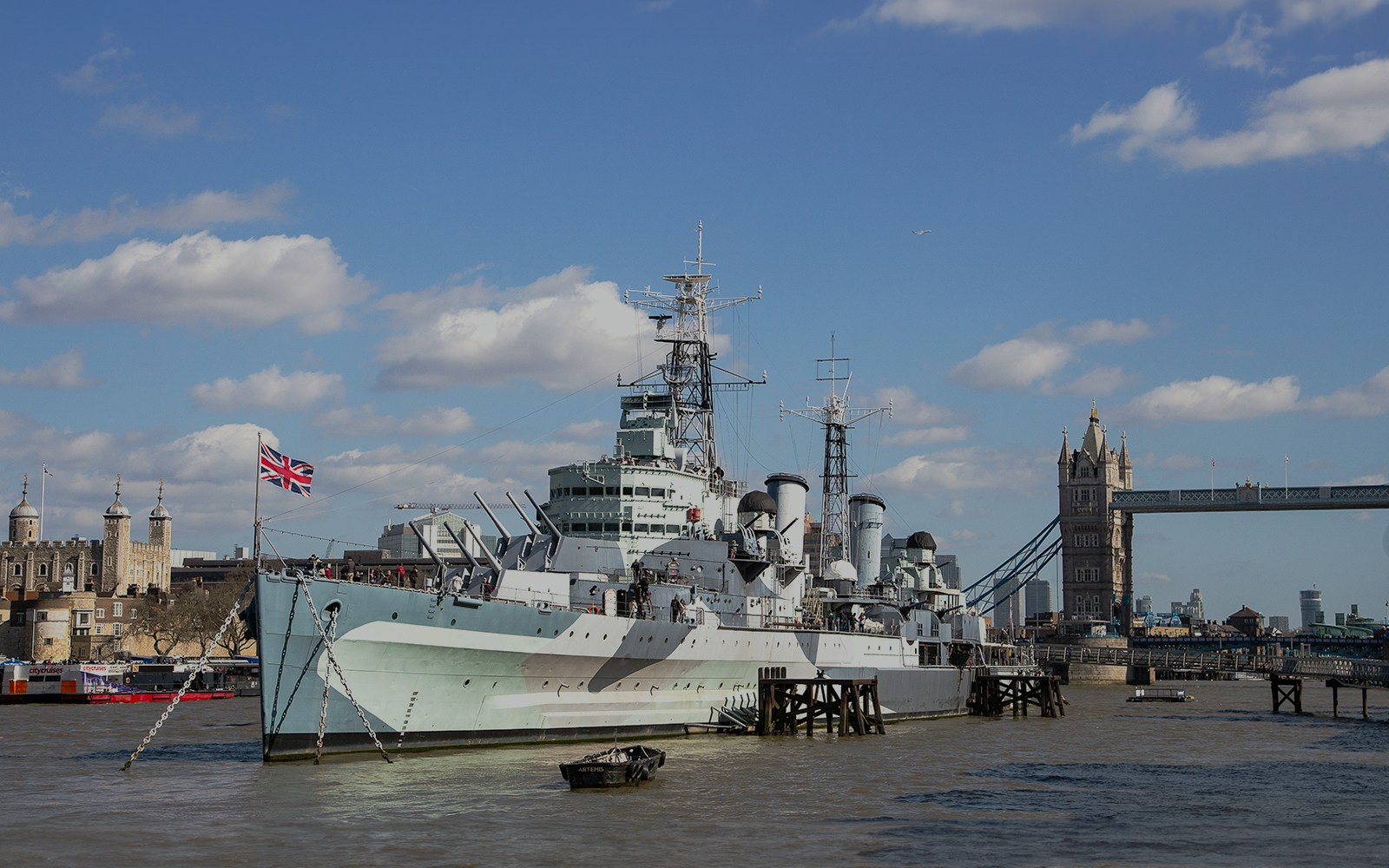 HMS Belfast moored on the River Thames with Tower Bridge in the background, London.