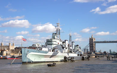 HMS Belfast moored on the River Thames with Tower Bridge in the background, London.