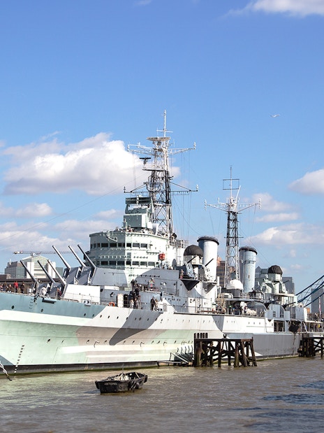 HMS Belfast moored on the River Thames with Tower Bridge in the background, London.