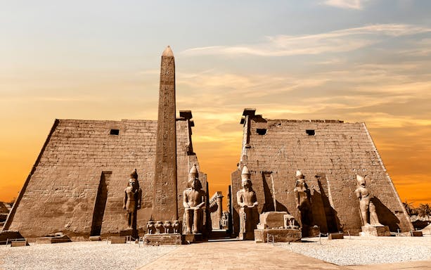 Luxor Temple entrance with statues and obelisk at sunset, part of 4-day Nile cruise.