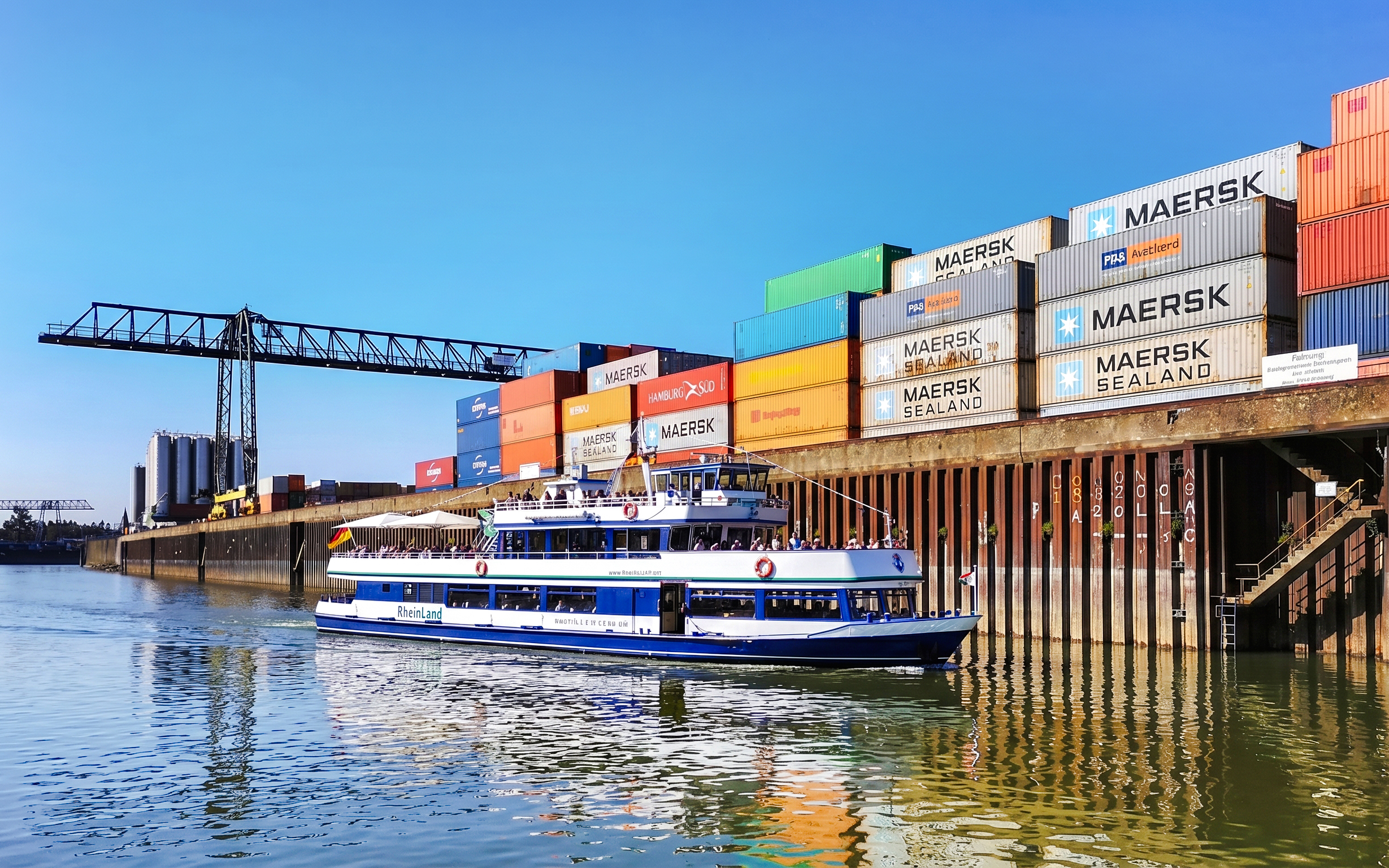 Cruise boat on Rhine River near Cologne container port.