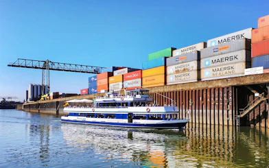 Cruise boat on Rhine River near Cologne container port.