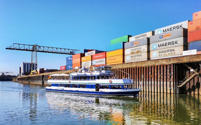 Cruise boat on Rhine River near Cologne container port.