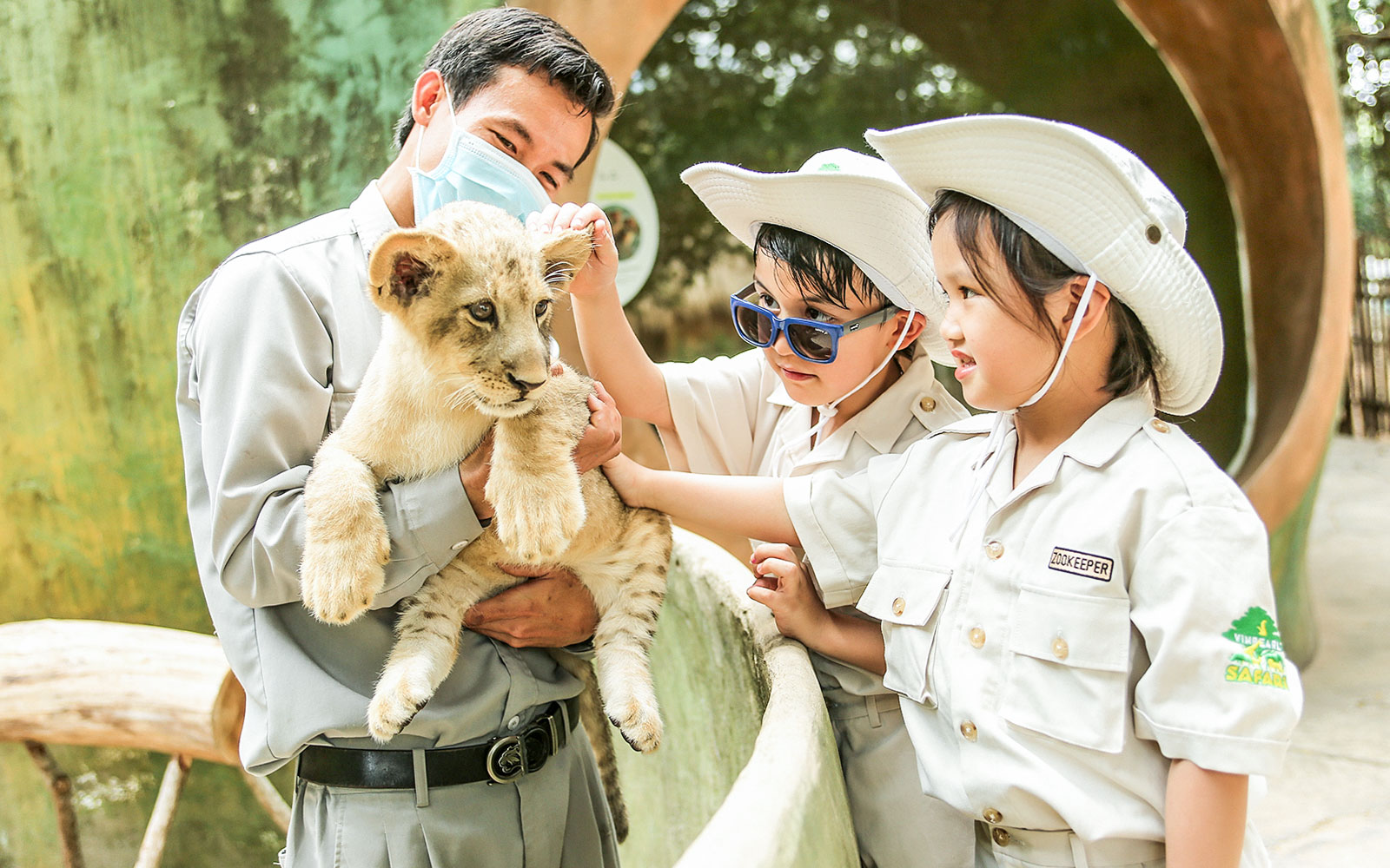 Children petting a lion cub at Vinpearl Safari.