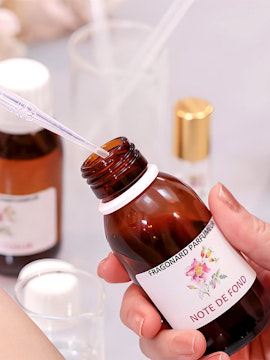 Fragonard Perfume Museum visitor holding a fragrance bottle with pipette.