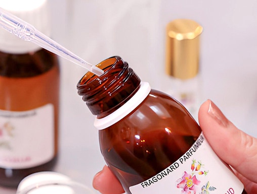 Fragonard Perfume Museum visitor holding a fragrance bottle with pipette.