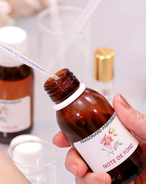 Fragonard Perfume Museum visitor holding a fragrance bottle with pipette.