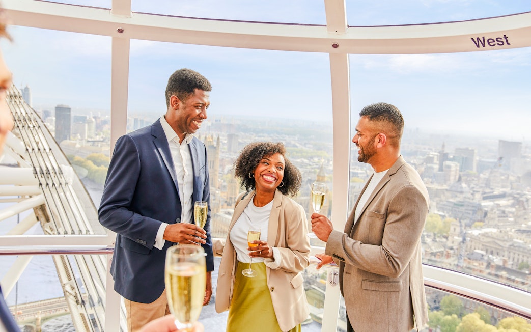 Guests enjoying champagne inside the London Eye capsule with city views.