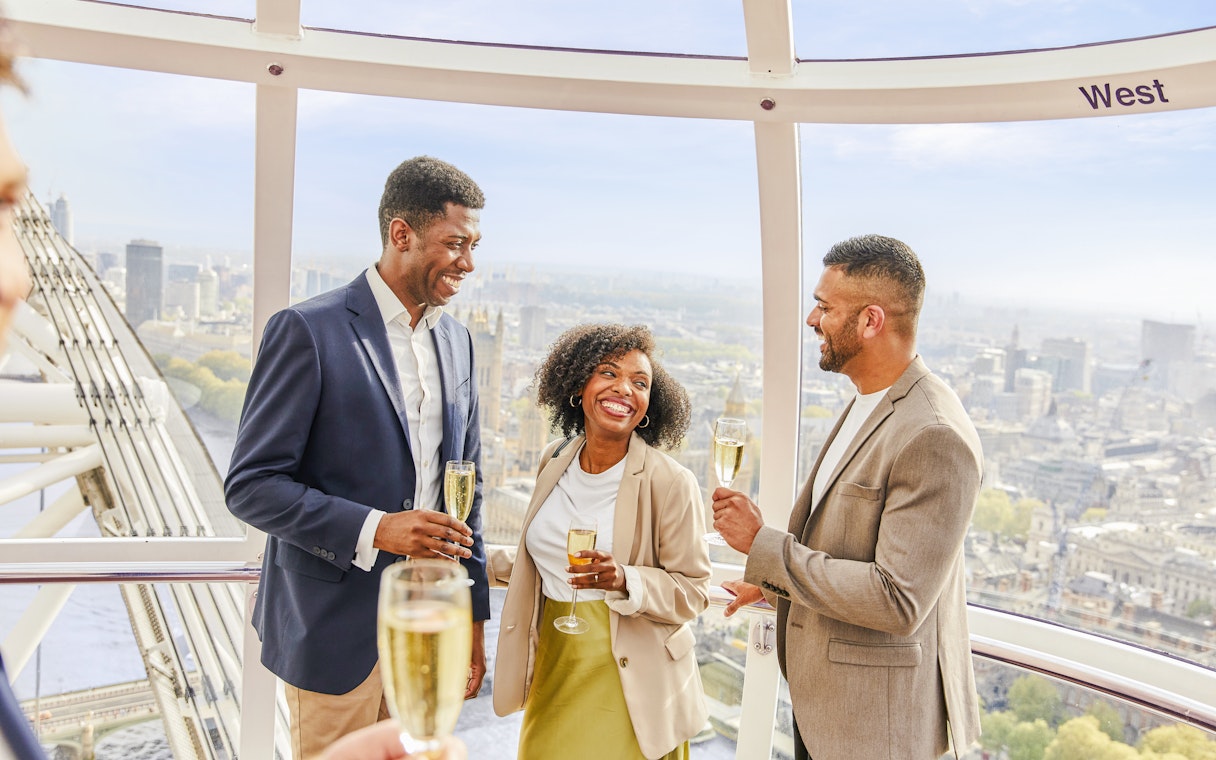 Guests enjoying champagne inside the London Eye capsule with city views.