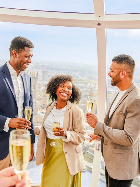 Guests enjoying champagne inside the London Eye capsule with city views.