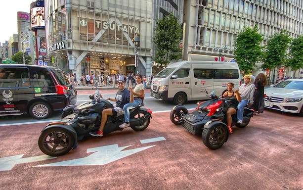 Go-kart riders on a street in Asakusa, Tokyo, with Tsutaya building in the background.