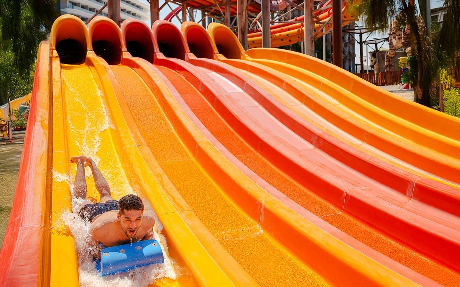 Person sliding down a colorful water slide at Meryal Waterpark, Distillers.