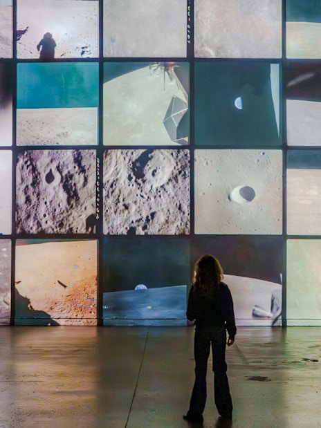 Visitors viewing lunar surface projections at The Moonwalkers Exhibition, Atelier des Lumières.