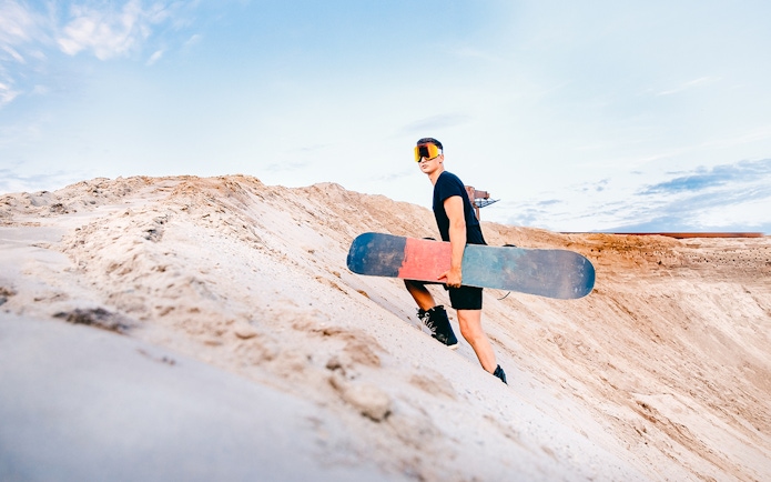 Snowboarder sand boarding on a dune in Australia.