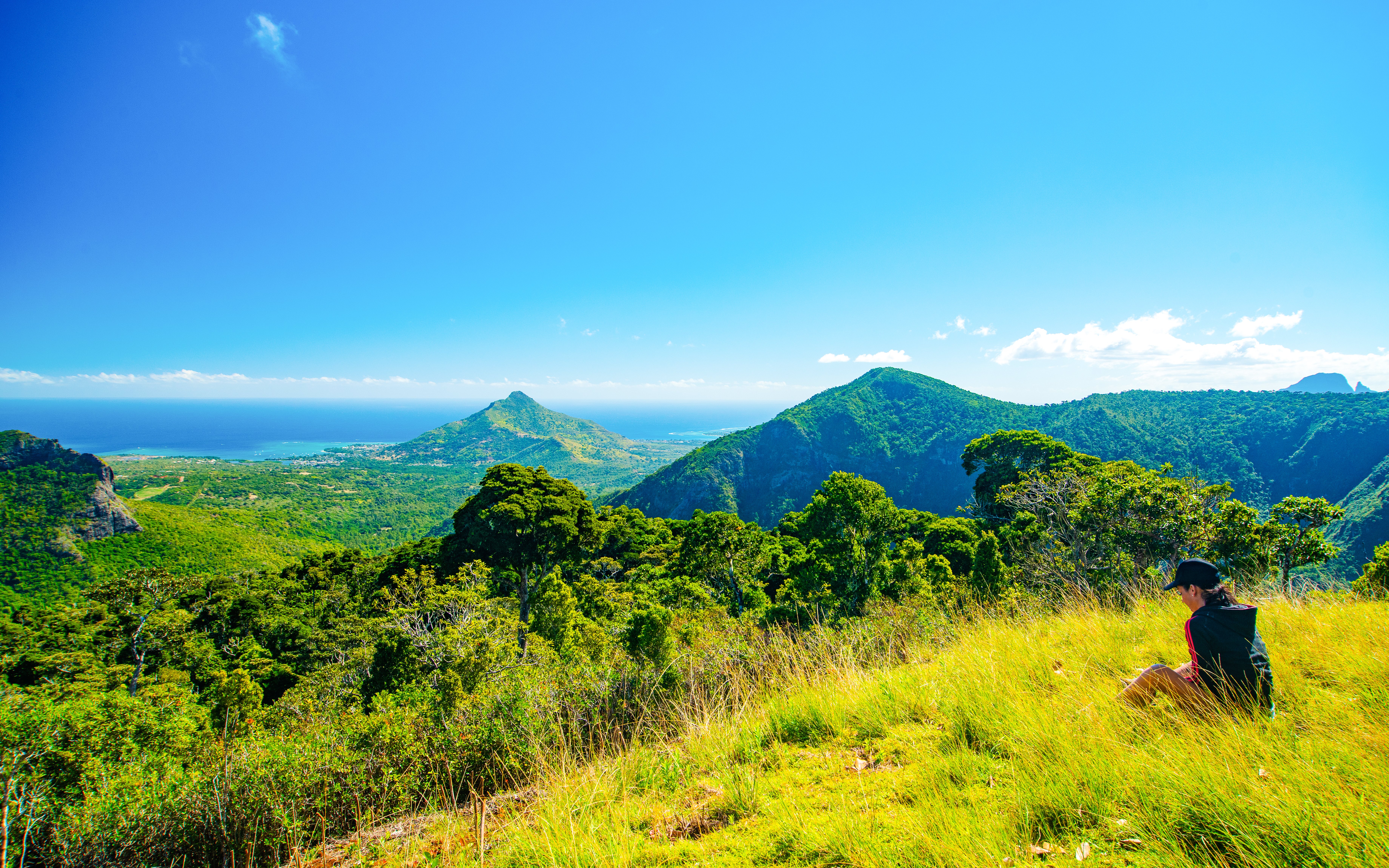 Scenic view of lush green mountains and ocean at La Vanille Nature Park, Mauritius.