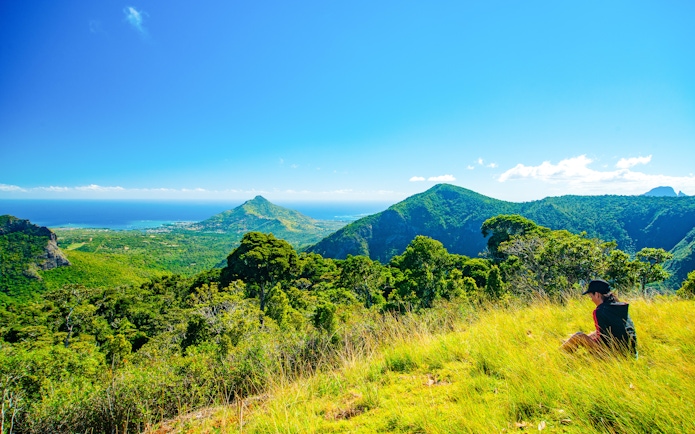 Scenic view of lush green mountains and ocean at La Vanille Nature Park, Mauritius.