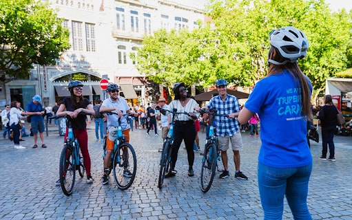 Group of cyclists with a guide in Old Town square during a bike tour.