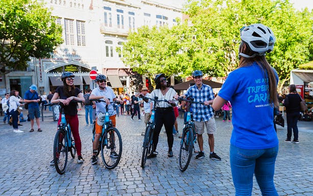 Group of cyclists with a guide in Old Town square during a bike tour.