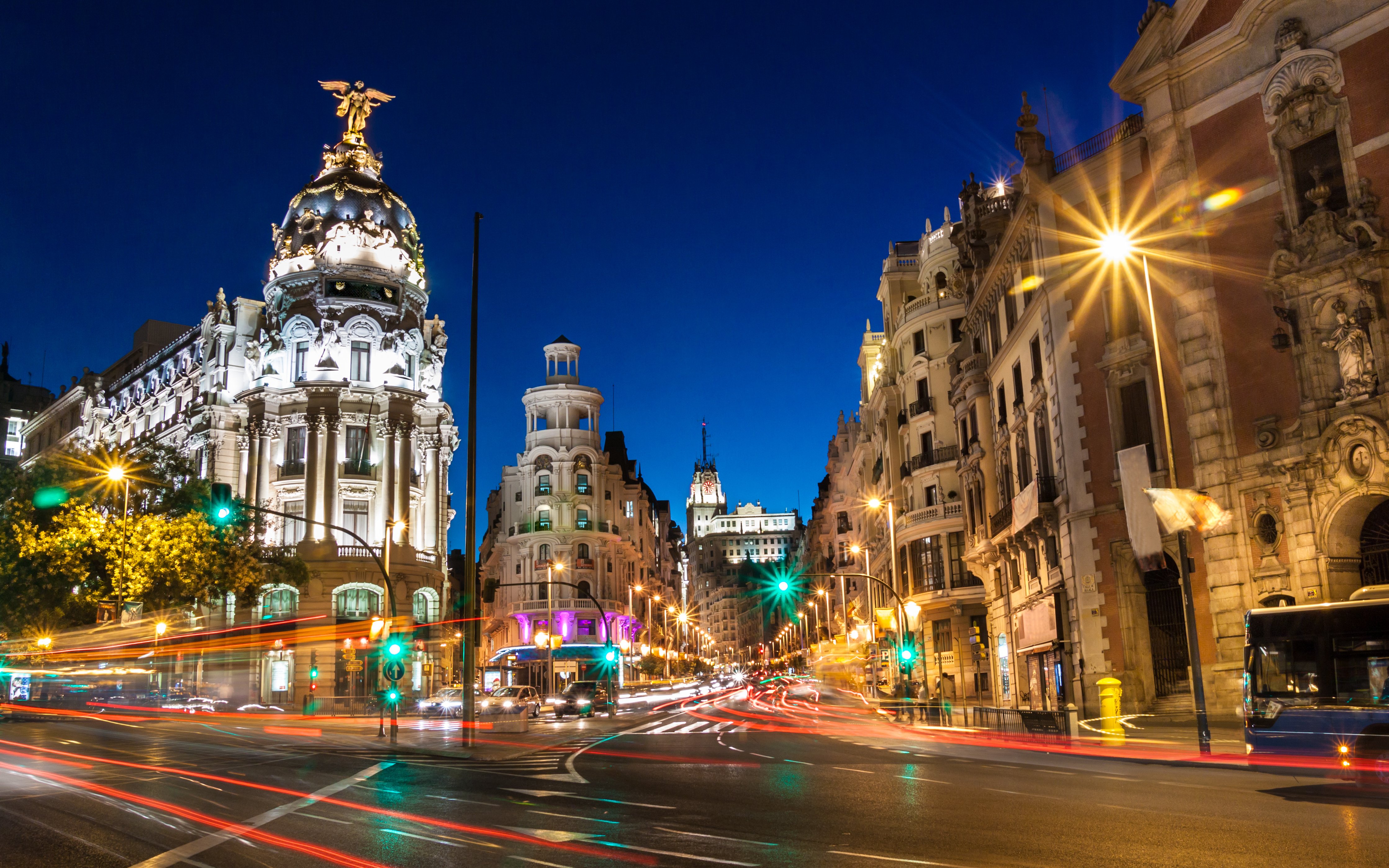 Gran Vía in Madrid illuminated at night with light trails from traffic.